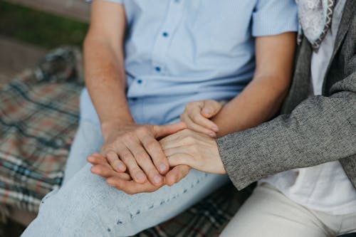 Two People Holding Hands Together