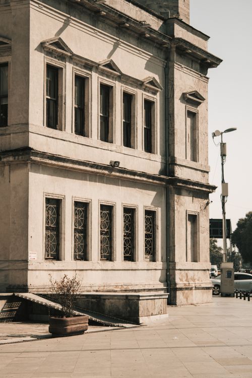 Free Old concrete building exterior with decorative windows in sunlight. Stock Photo