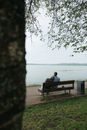 Woman Sitting on Bench Near Body of Water