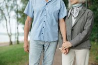 Man in Blue Button Up Shirt Holding Woman in Gray Dress