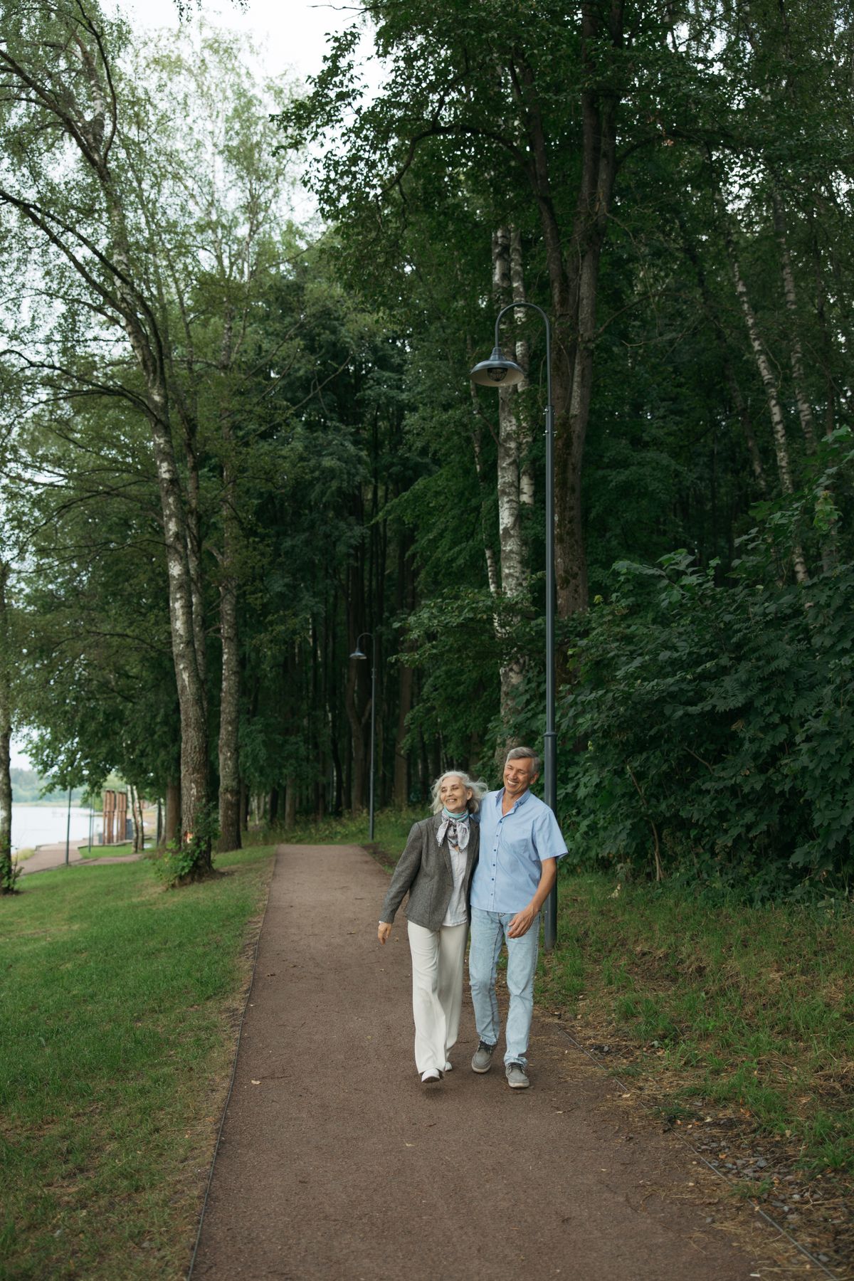 Senior couple enjoying a walk along a tree-lined path in a park