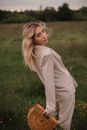 Girl in Beige Long Sleeve Shirt Standing on Green Grass Field