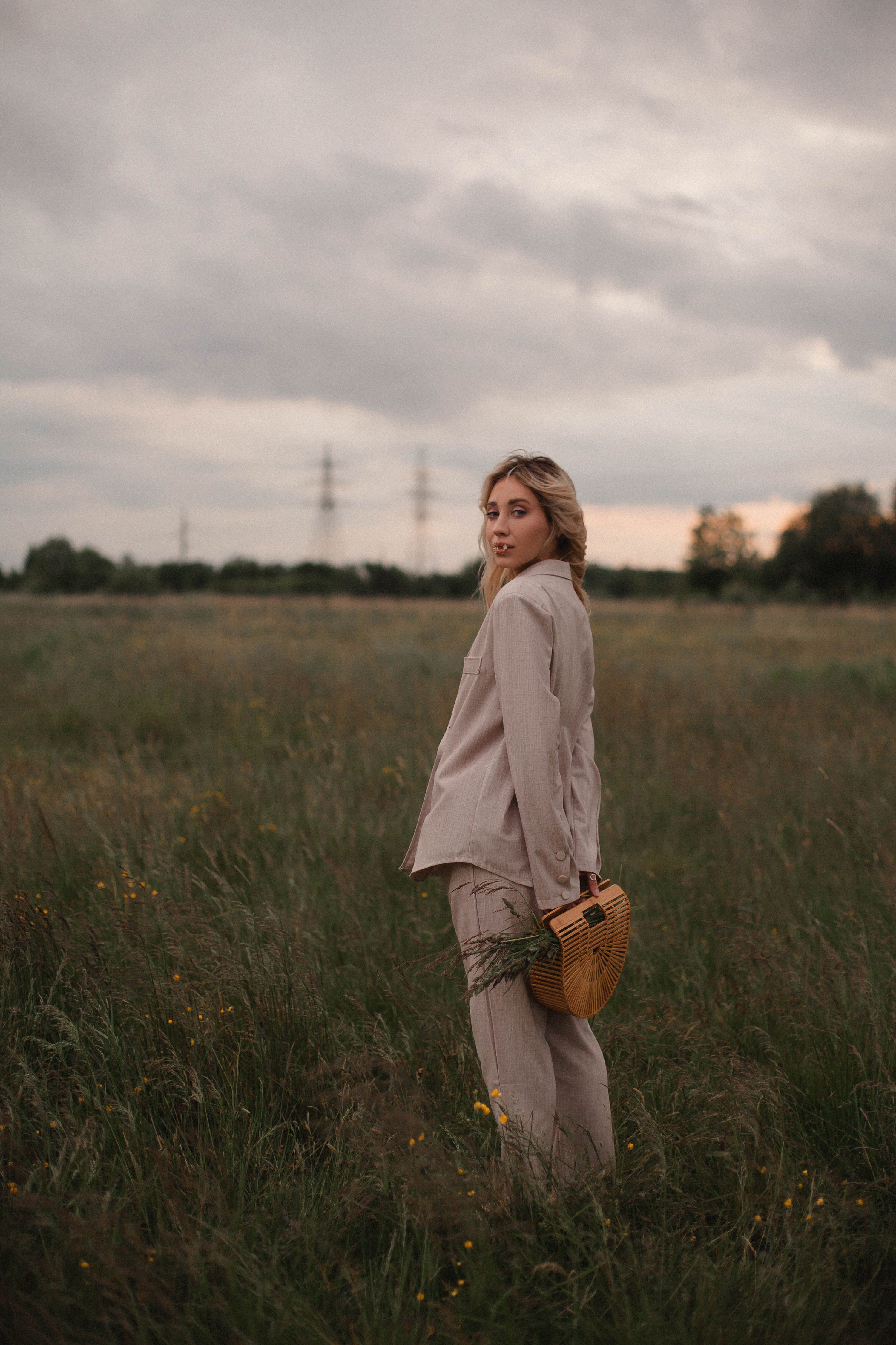 A Blonde Woman in Beige Suit Standing on the Grass · Free Stock Photo