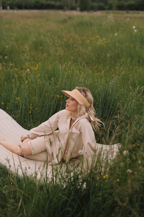 Free Woman Sitting on a Blanket on Grass Field Stock Photo
