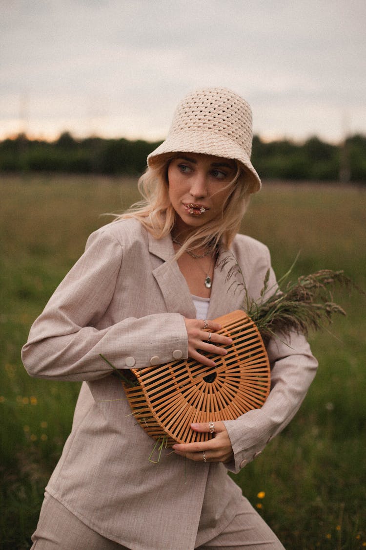 Woman With A Hat Holding A Bag With Grass