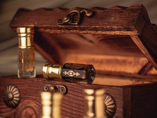 Gold and Clear Glass Bottles on Brown Wooden Chest