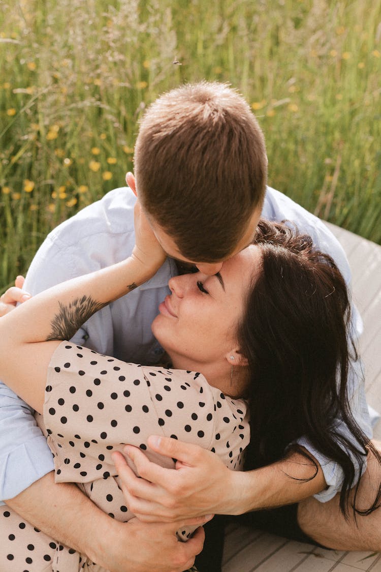 Man Kissing A Woman In White And Black Polka Dot Shirt 