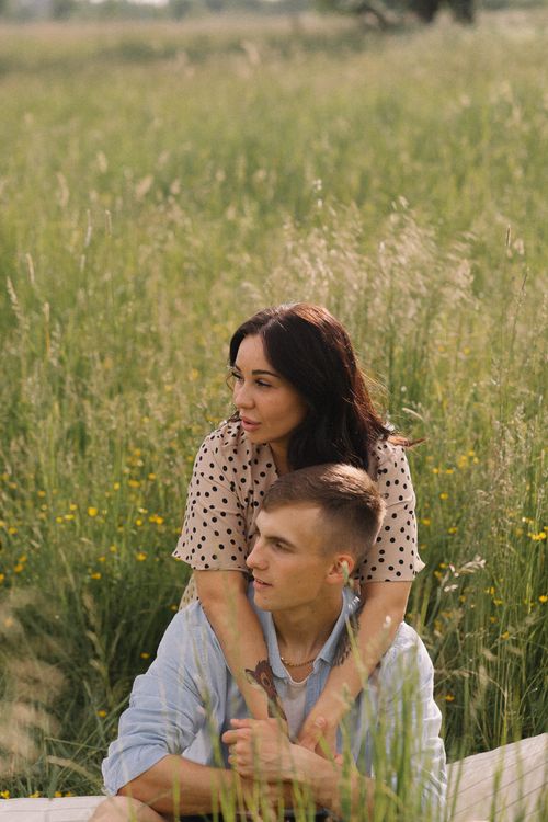Free Young couple enjoying a serene moment together in a lush, sunlit meadow. Stock Photo