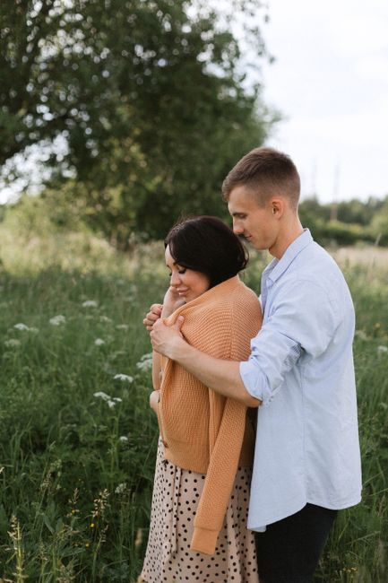 A happy young couple enjoying a moment together outdoors in a sunny meadow.