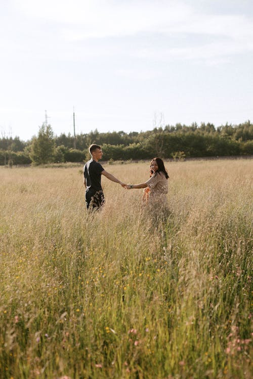 Couple walking on a Grass Field 