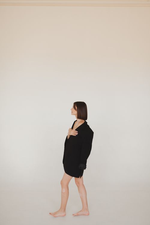 Free Stylish woman in a black outfit posing in a minimalist studio. Stock Photo