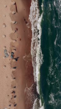 Aerial shot capturing the pristine Baltic Sea waves crashing against a sandy beach.