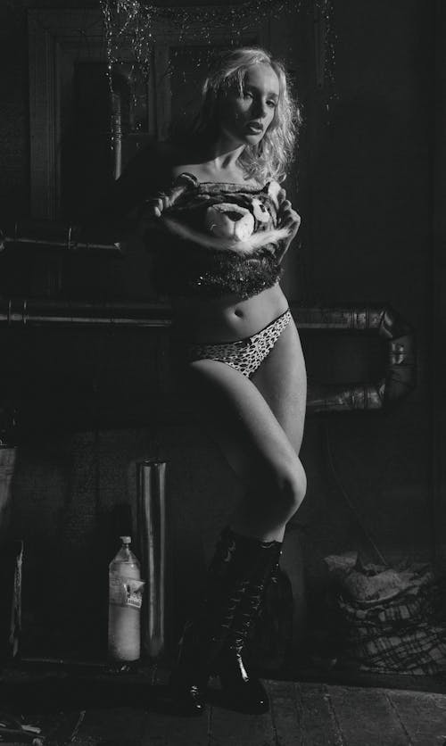 Grayscale Photo of a Topless Woman Wearing Panty Covering Her Chest with a Mask
