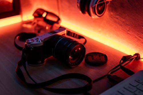 Free Retro camera on a desk with warm ambient lighting, evoking a nostalgic vibe. Stock Photo