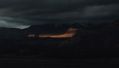 Free Moody mountain scene with dramatic lighting and stormy clouds. Stock Photo