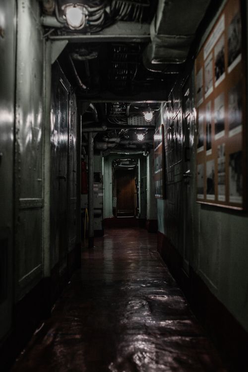 Free A creepy, dimly lit hallway with dark shadows, evoking an eerie atmosphere. Stock Photo