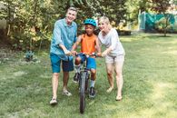 Man and Woman Helping a Boy Riding a Bicycle