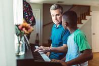 Man Sitting Beside a Boy in Front of a Piano