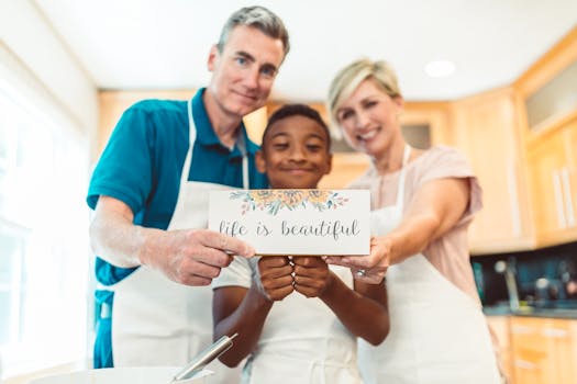 Happy family of three bonding while cooking in the kitchen and holding a positive message card.