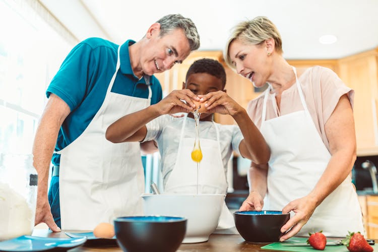 Couple Watching A Boy Break An Egg