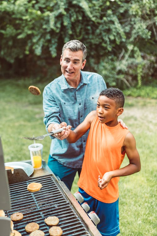 Father and Son Grilling Patty on the Gardedn