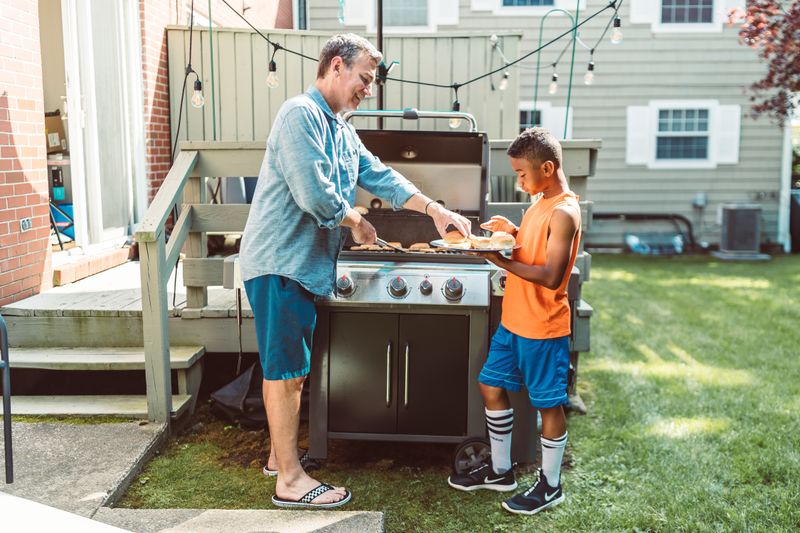 Family grilling together BBQ island Meridian Idaho backyard
