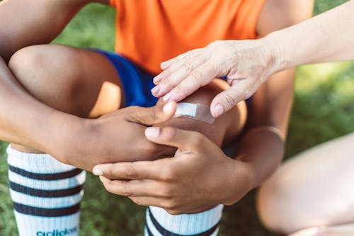 A Hand Touching the Band-Aid on Person's Toe