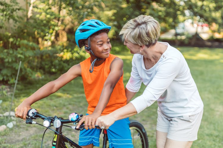 A Mother Teaching Her Son How To Ride A Bicycle