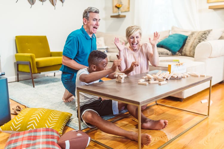 A Family Laughing At A Collapsed Building Blocks