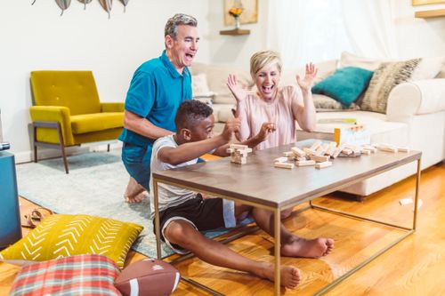 Free Family enjoying a playful moment indoors while building with wooden blocks. Stock Photo