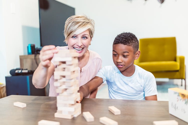 Woman And A Child Stacking Wooden Blocks