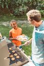 A Child in Orange Sleeveless Shirt Holding a Plate of Food