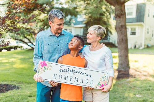 A Family Holding a Happiness is Homemade Placard