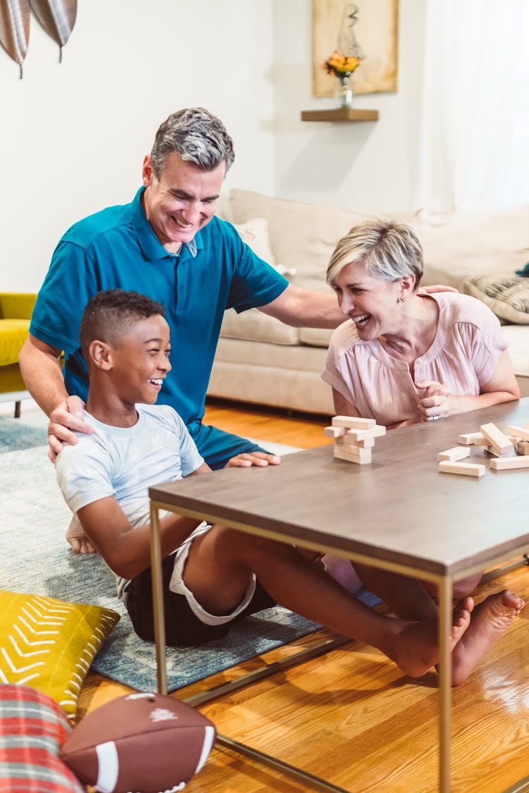 A Happy Family Playing Jenga In The Living Room