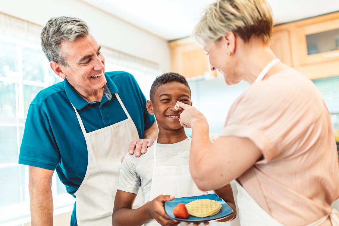 Woman Putting Whipped Cream on the Boy's Nose 