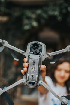 Close-up of a person holding a drone, showcasing modern technology in a vertical shot.