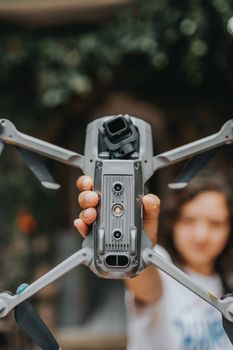 Close-up of a person holding a drone outdoors highlighting modern technology.