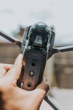 Detailed view of a hand gripping a Mavic drone, showcasing modern technology.