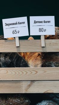 Variety of fresh baguettes with prices displayed in Vladivostok market.