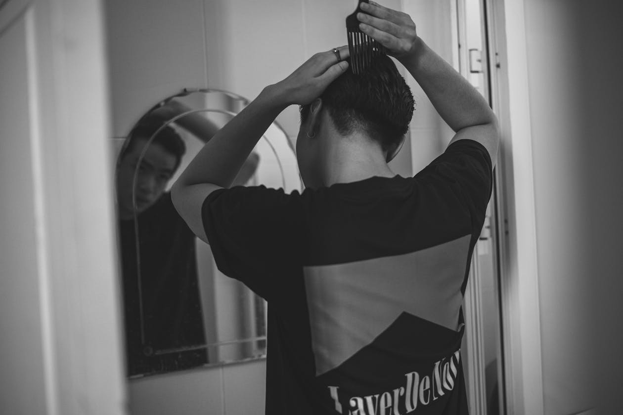 Man examining his hairline in a mirror