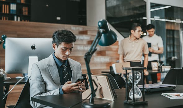 Business professionals in suits working at office desks, showcasing modern corporate environment.