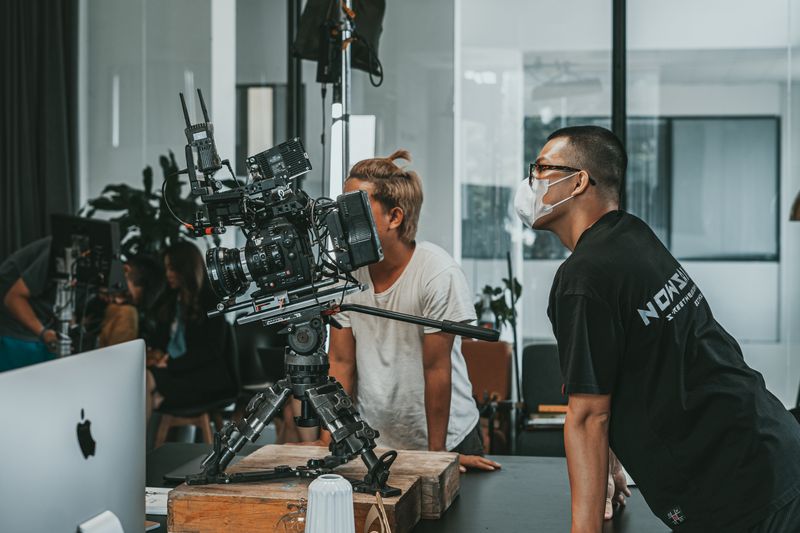 A professional film crew collaborates in a modern studio setting, focusing on high-end camera equipment.