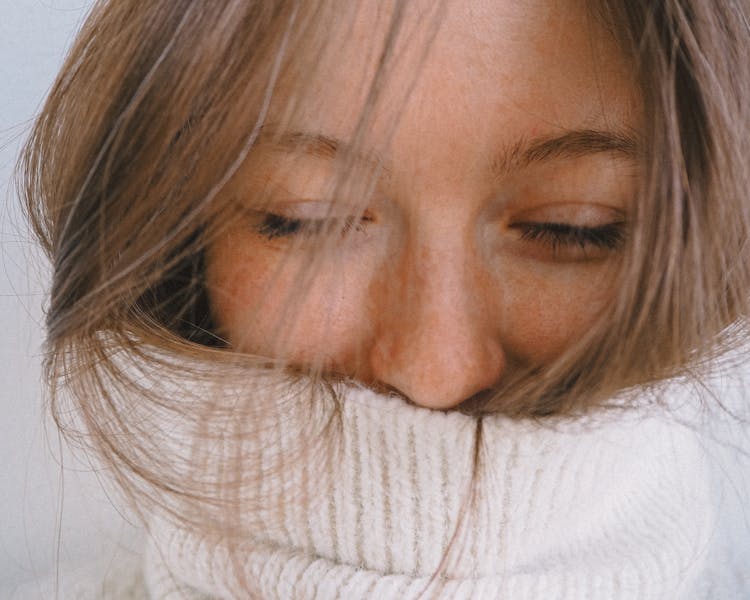 Woman With Her Eyes Closed In White Turtleneck Sweater