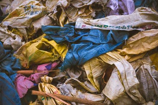 A vibrant mix of discarded textile bags in a recycling pile, showcasing the importance of waste management.