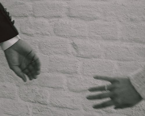 Monochrome Photo of Two People's Hands