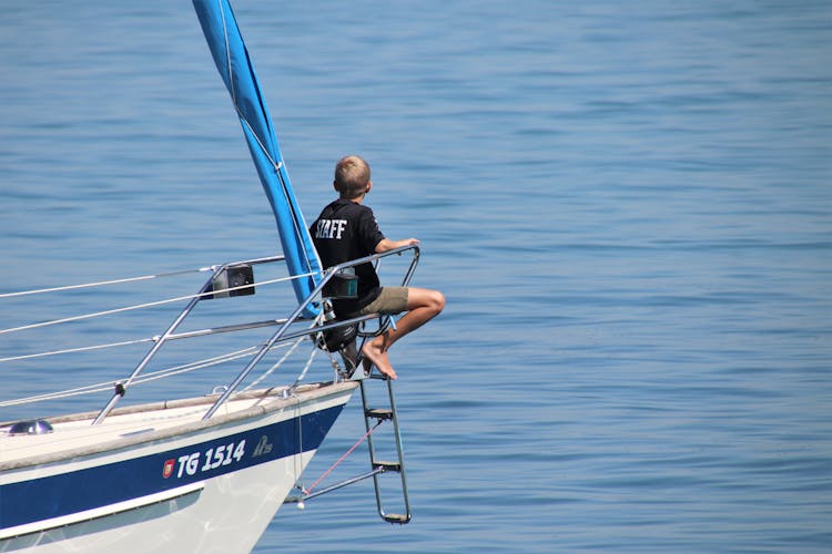 A Boy Sitting On The Bow Of The Boat