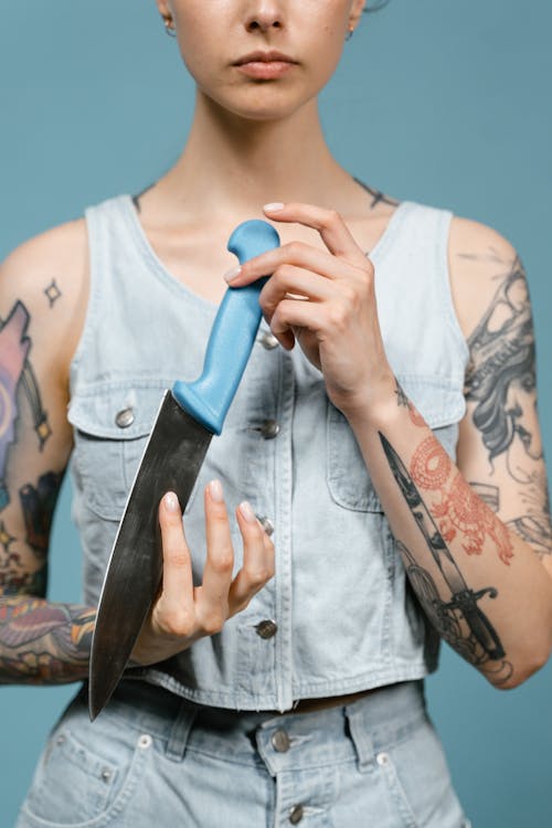 Woman in Denim Top holding a Knife