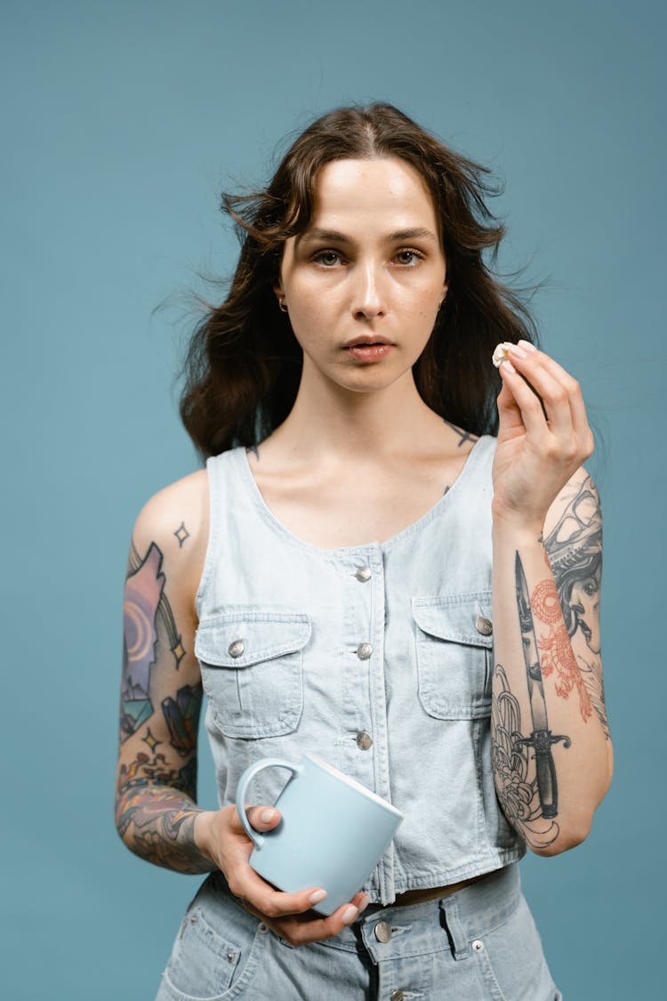 Woman With Arm Tattoo Holding A Mug