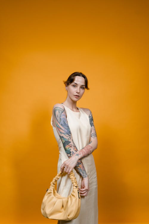 Woman with Arm Tattoo Holding Yellow Bag