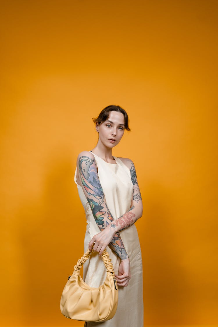 Woman With Arm Tattoo Holding Yellow Bag